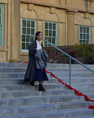 A students performs a play outdoors on the library steps